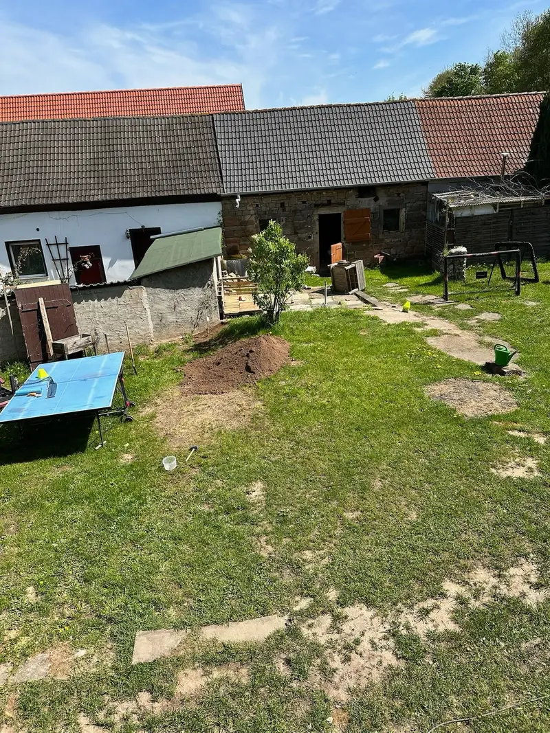 Blick auf den Hof mit Tischtennisplatte und Trampolin