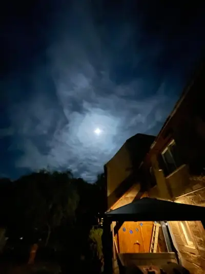Mond über dem beleuchteten Pavillon bei Nacht