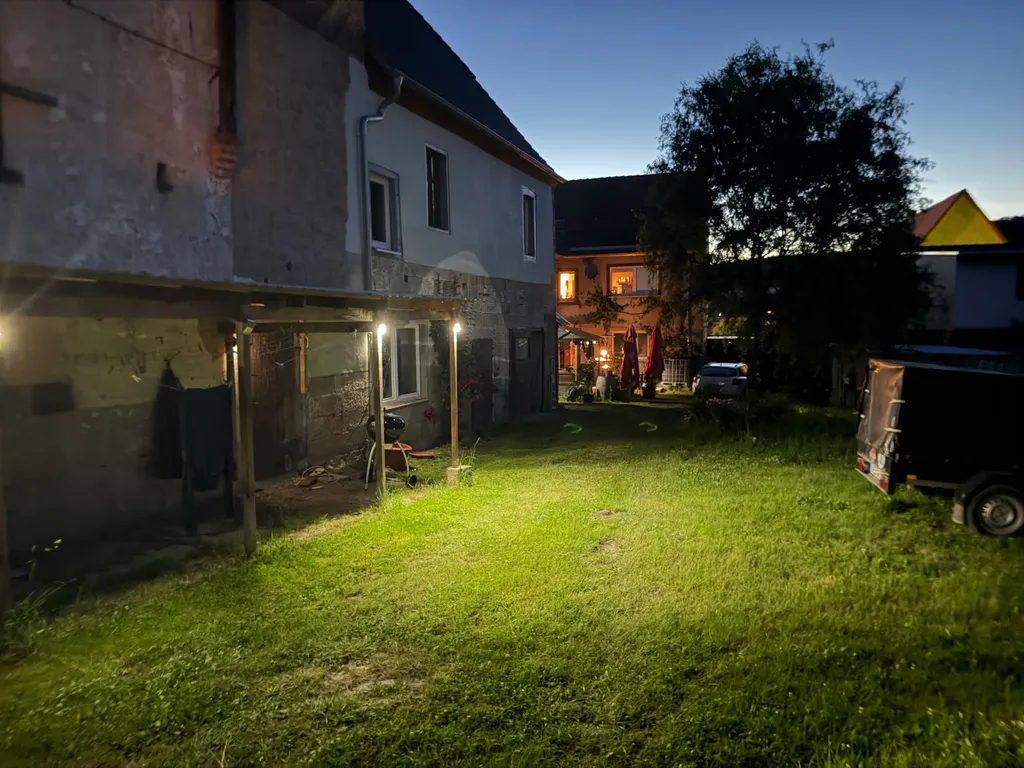 Hof in der Abenddämmerung mit beleuchteten Fenstern