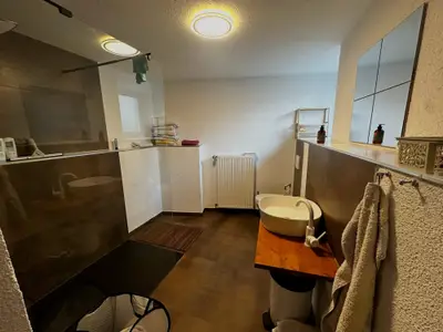 Himmelsscheibe Bad mit begehbarer Dusche und Waschtisch