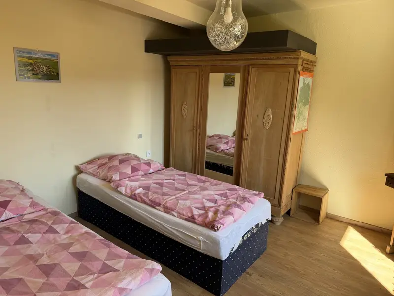 Himmelswege Schlafzimmer mit Einzelbett und Holzschrank