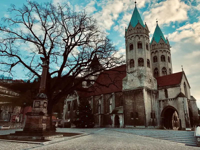 Romanische Kirche mit grünen Doppeltürmen