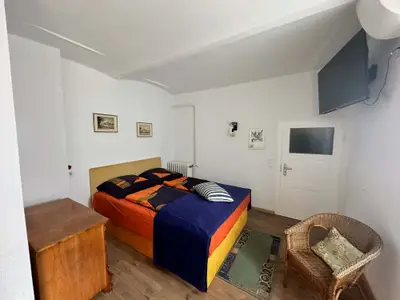 Unstruttal Schlafzimmer mit Doppelbett und Korbsessel